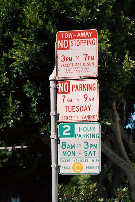 A blue parking sign with a white 'P' and a wheelchair symbol indicating accessible parking, mounted on a silver metal pole against a dark grey wall. The shadow of the sign is cast onto the wall. This scene is outdoors, likely on a pavement or driveway adjacent to a building, and is relevant to parking arrangements for home relocation or furniture transport in the context of house removals. The sign is positioned slightly to the right of the image, with part of the pavement visible at the bottom. The lighting is natural, illuminating the sign clearly for accessibility purposes, supporting the process of loading or unloading furniture during a move with professional removals. Occasionally, Man with Van Pinner advising on parking permits for Pinner moves can benefit from clear signage like this for access during classified parking suspension applications.
